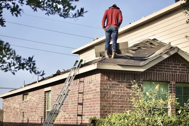 Professional roofer working on a residential roof in Polson